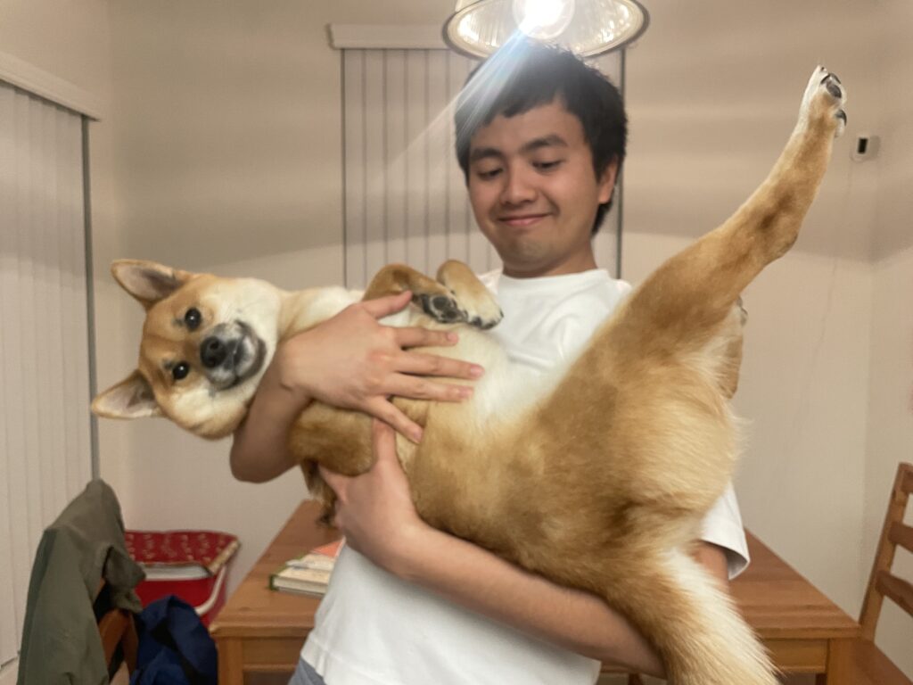 photo of a man in a white shirt holding a dog