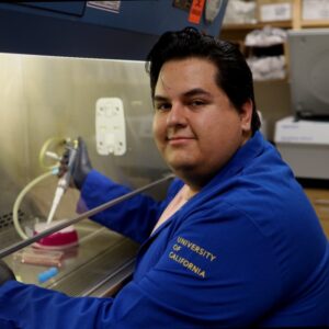 Photo of a man with dark hair working in a lab. 